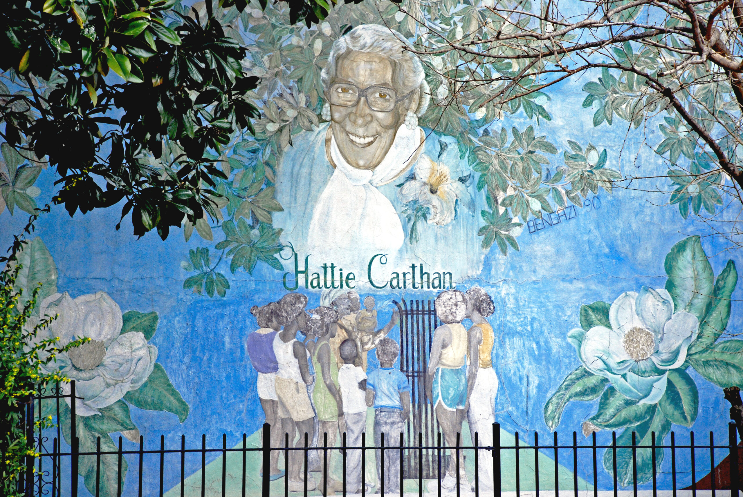 A mural depicting Hattie Carthan, a group of people, and flowers on a blue backdrop