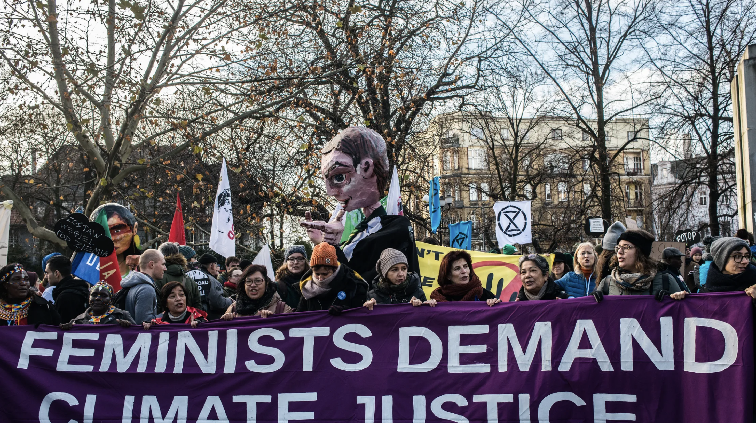 Protesters hold a sign that reads "feminists demand climate justice"