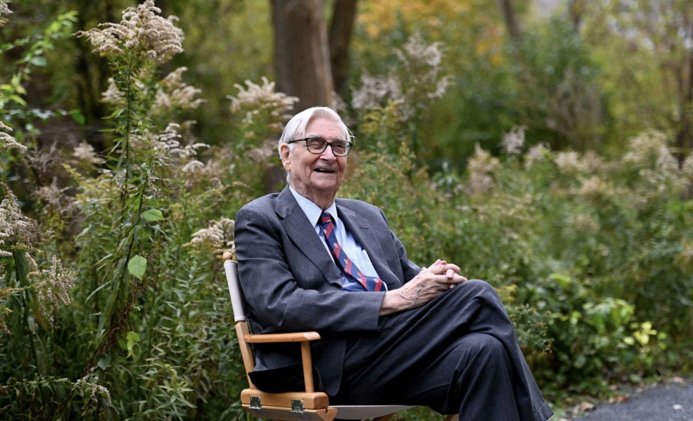 Edward Osborne Wilson smiling on a park bench