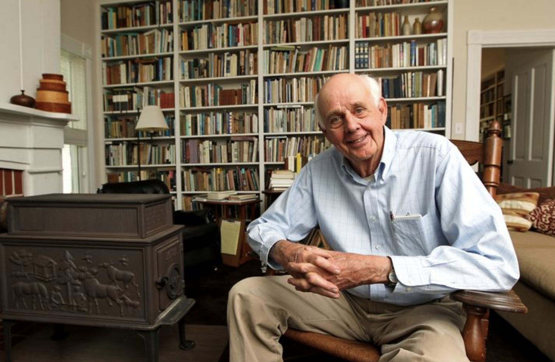 A photo of Wendell Berry in front of bookshelves