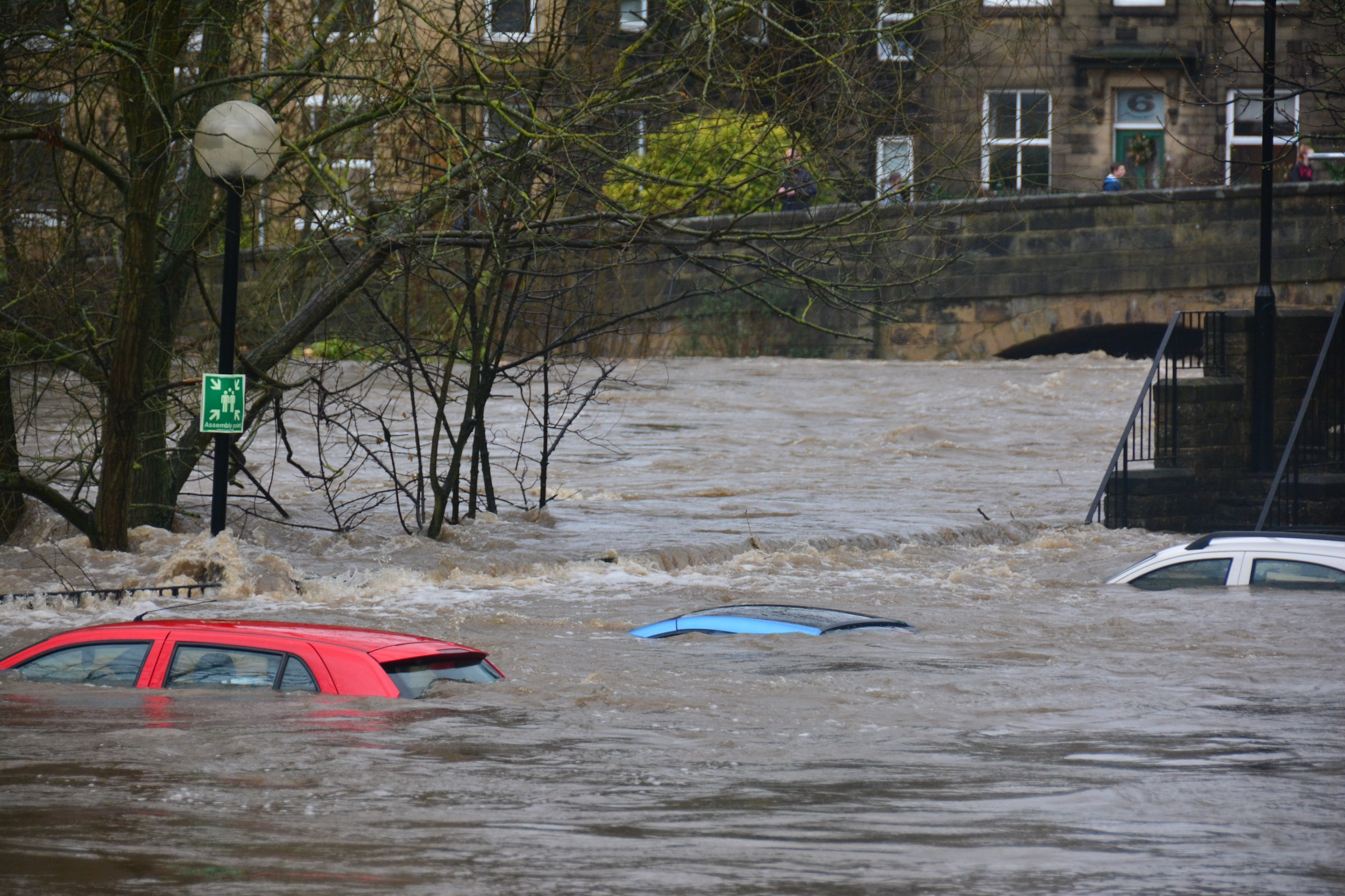 Three cars are almost entirely submerged in floodwaters