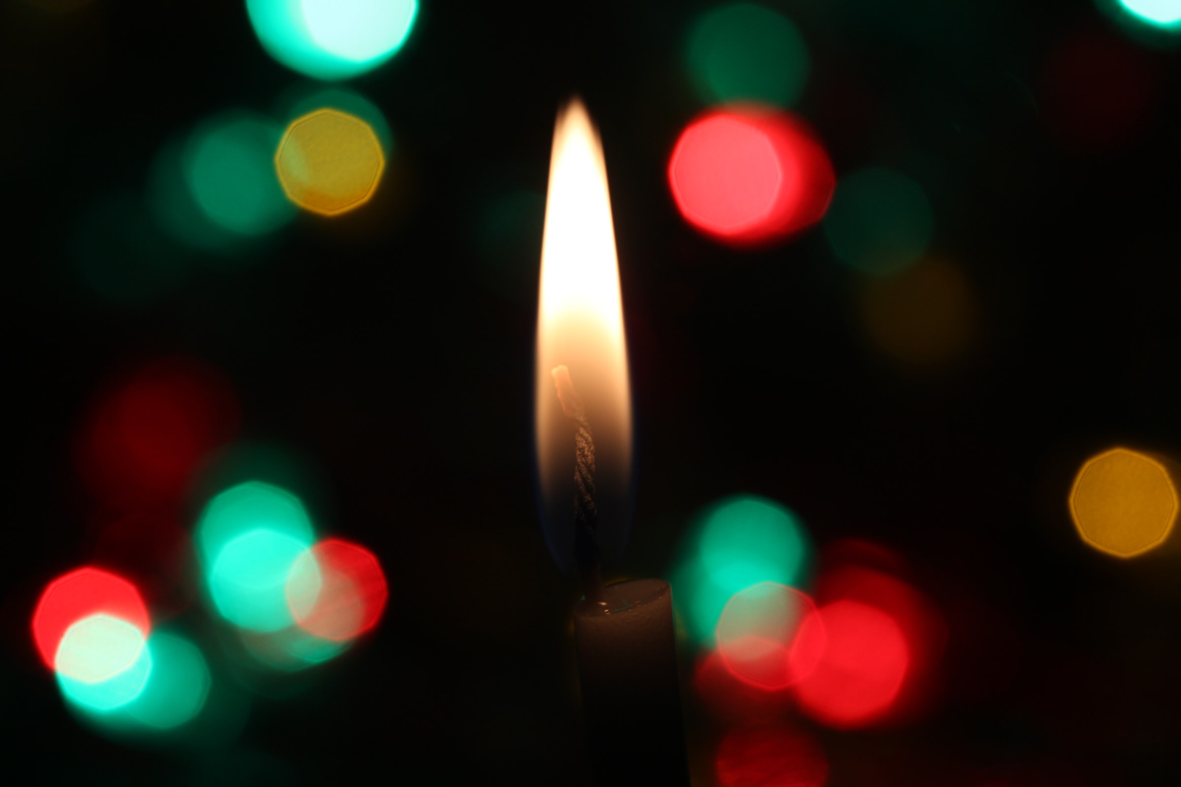 A close-up of a candle flame reflected in glass