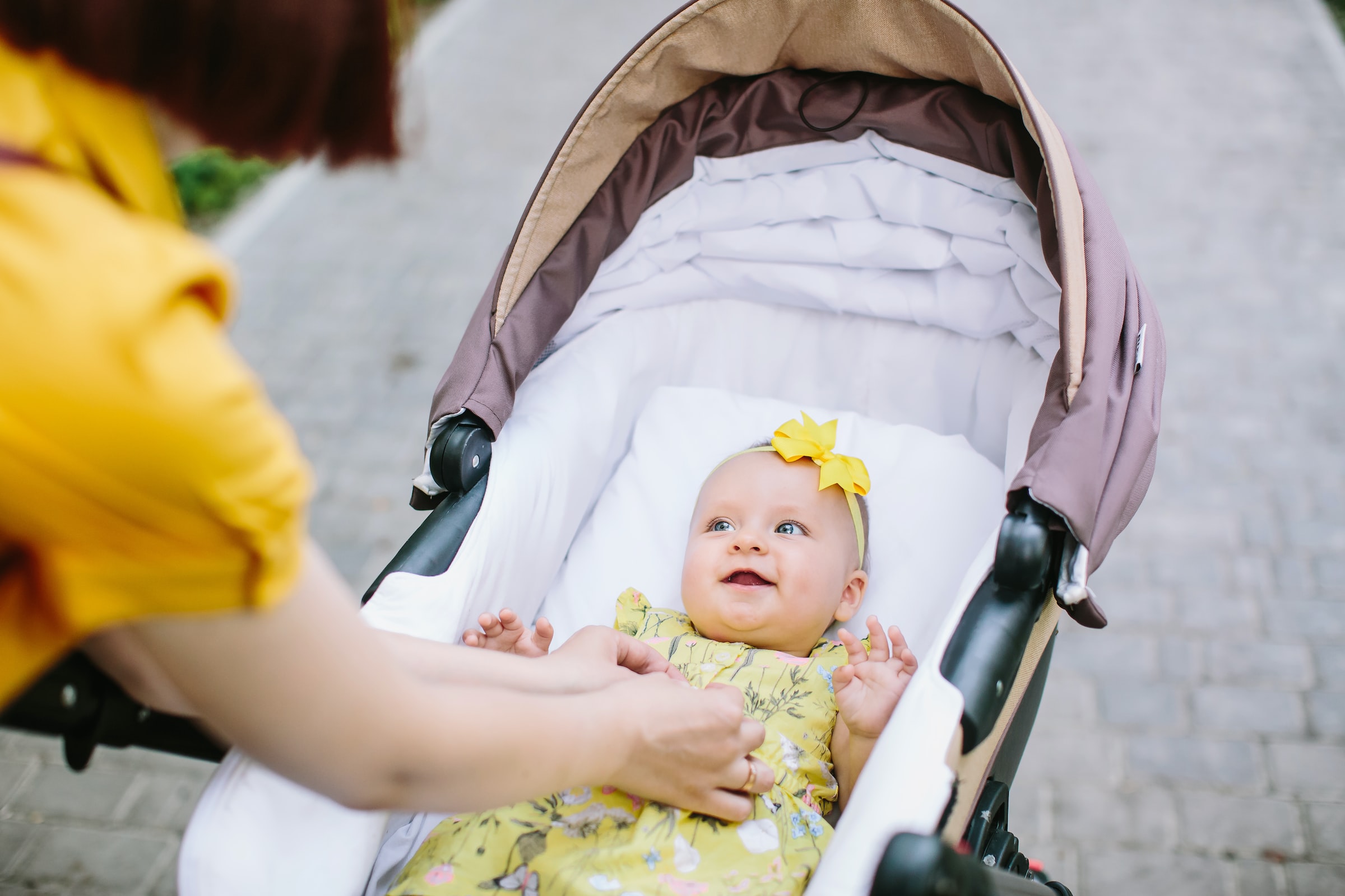 A baby smiles in a stroller