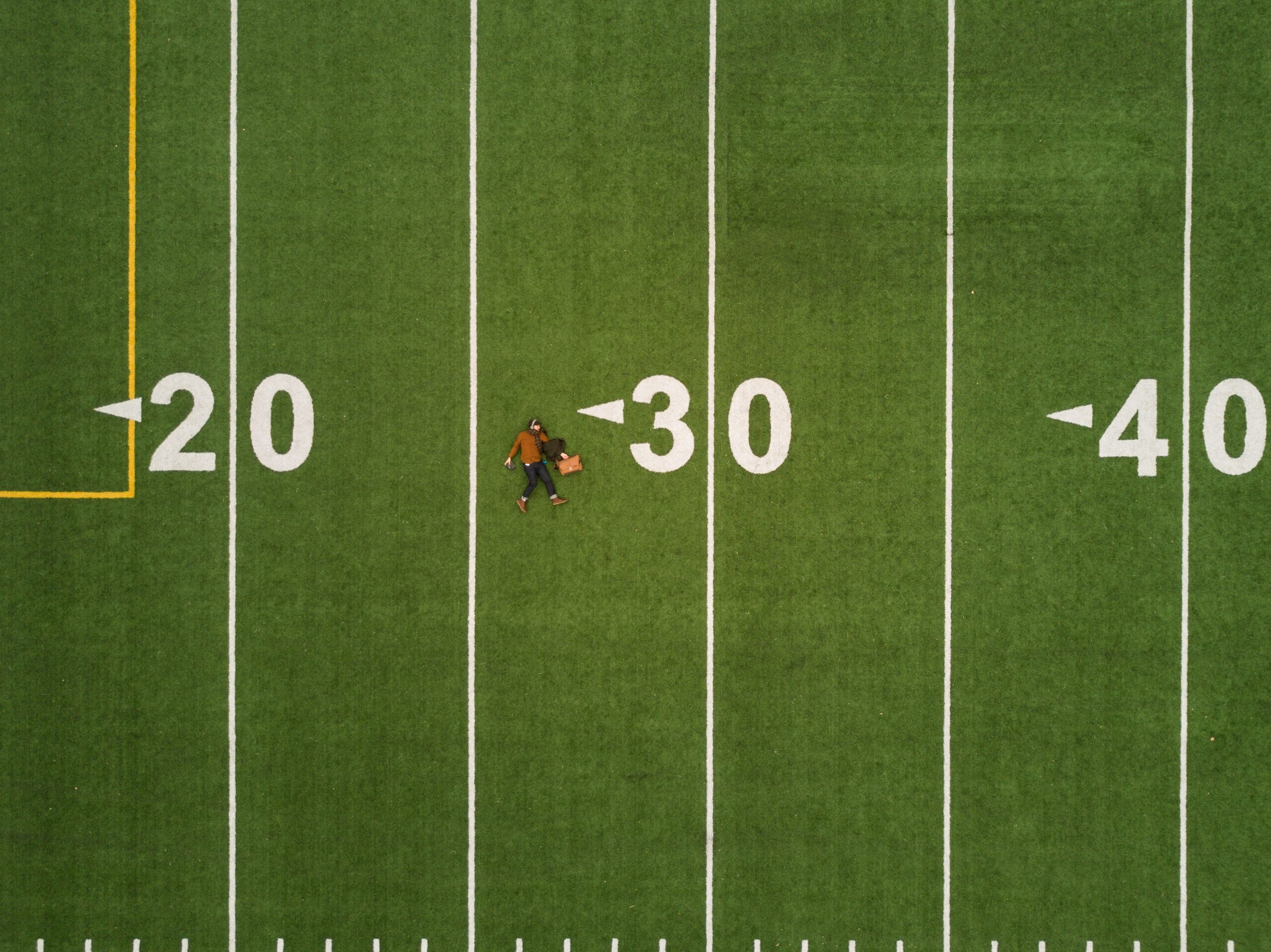 A football field and one person walking viewed from above