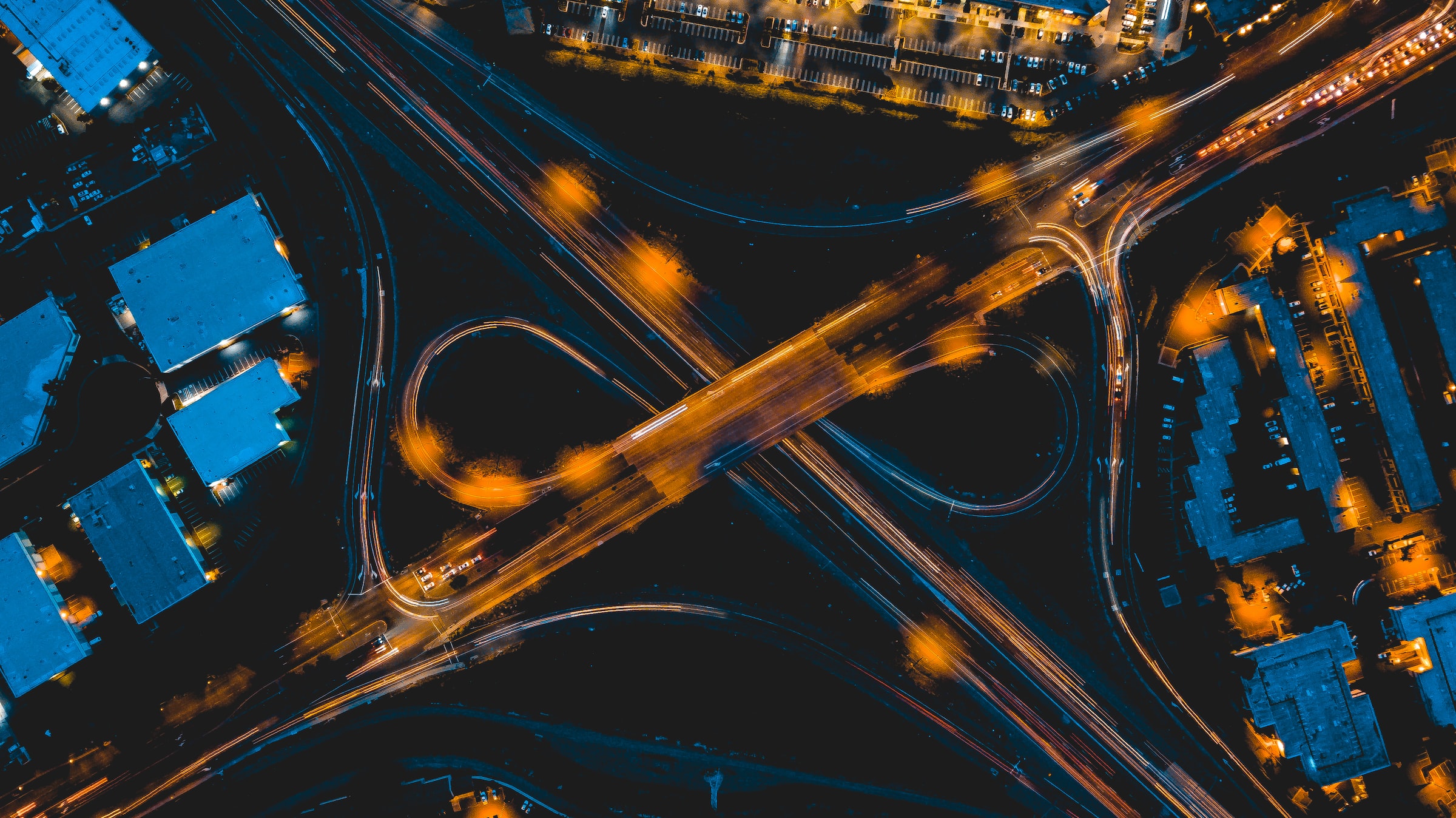 A highway interchange is viewed from above at night