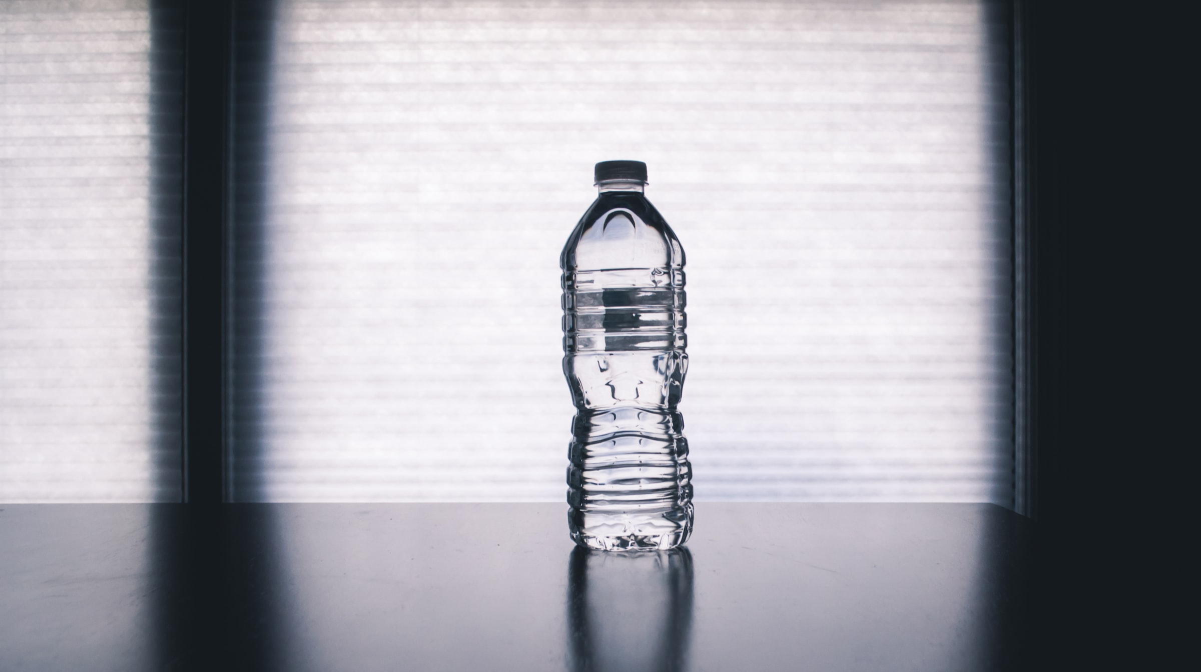 A plastic water bottle seen through bars