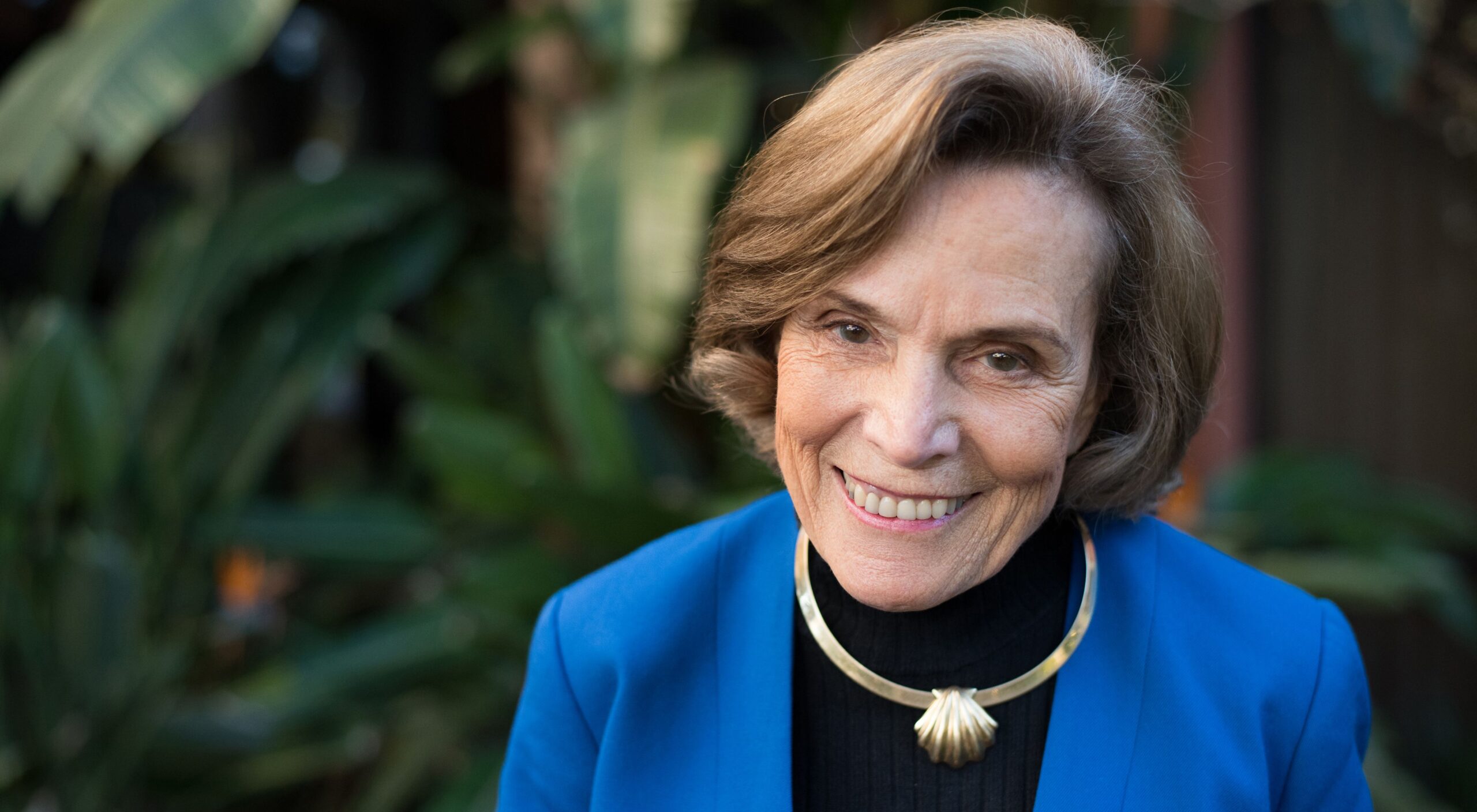 Dr. Sylvia Earle smiling in front of foliage