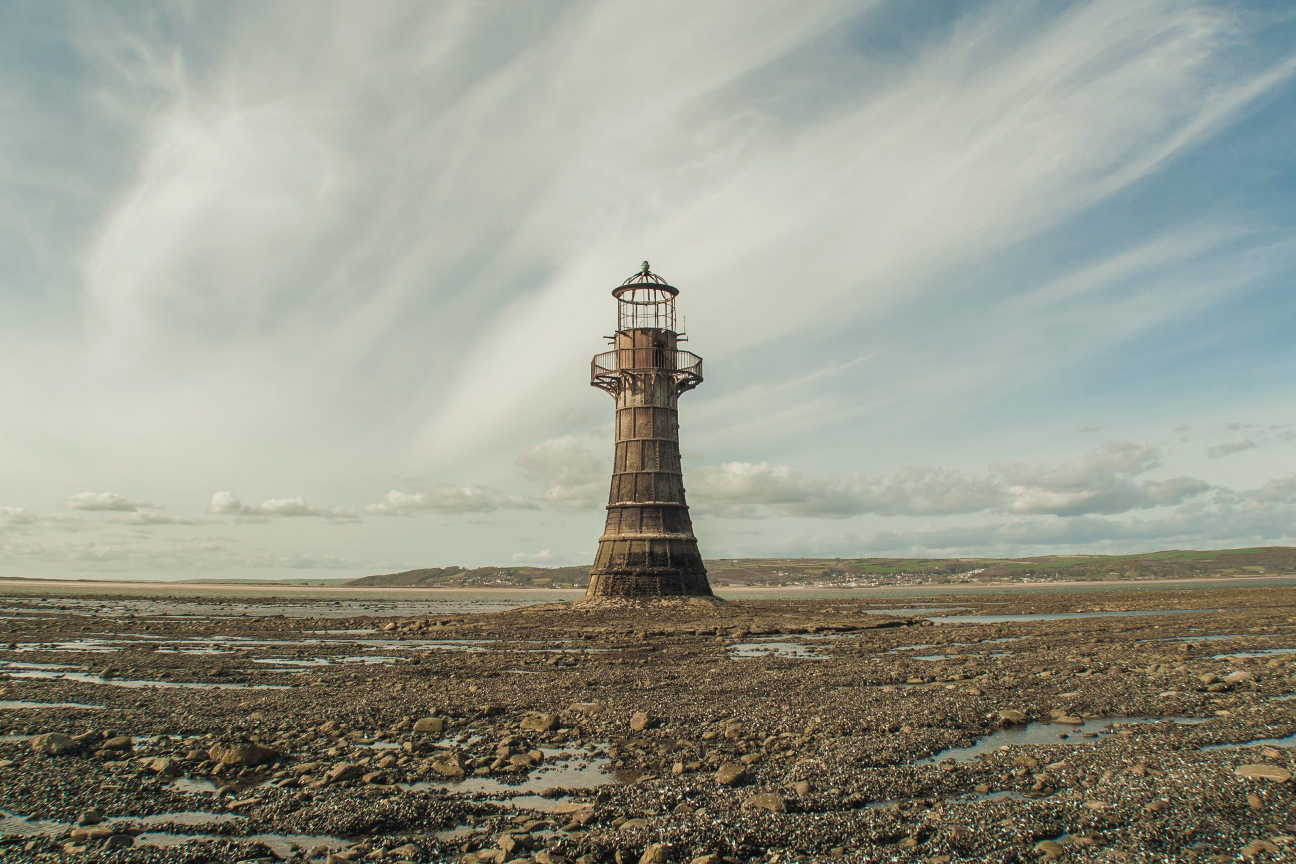 A decayed lighthouse in a desolate low tide looking zone.