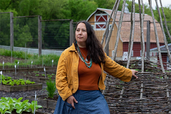 Image of Rowan White on a farm in front of a wooden structure.